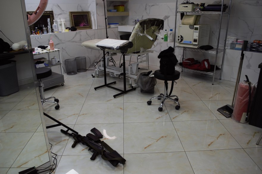 A tattoo table and a gun nearby under a building in Kyiv, Ukraine.