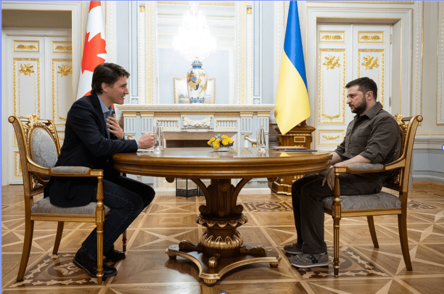 Former Canadian Prime Minister Justin Trudeau and Ukrainian President Volodymr Zelenskyy sit at a table.